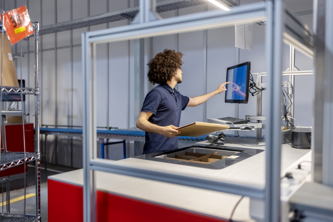 Eine Person arbeitet im automatisierten Paketlager